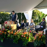a-man-speaks-at-a-podium-during-a-temple-groundbreaking-ceremony