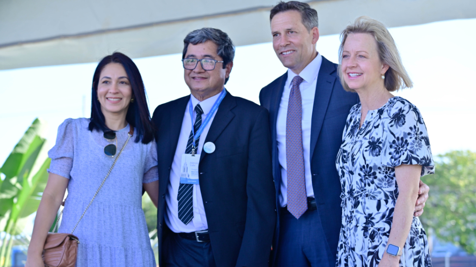 two-couples-stand-together-outside-at-the-groundbreaking-ceremony